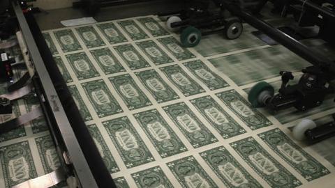 Sheets of one dollar bills run through the printing press at the Bureau of Engraving and Printing on March 24, 2015 in Washington, DC (Photo by Mark Wilson/Getty Images)