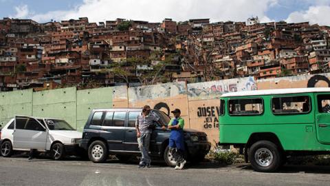 Two men talk while they line up to get subsidized gasoline on June 5, 2020 in Caracas, Venezuela (Photo by Leonardo Fernandez Viloria/Getty Images)