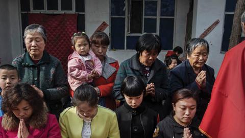 Chinese Catholic worshippers wait to take communion at the Palm Sunday Mass during the Easter Holy Week at an "underground" or "unofficial" church on April 9, 2017 near Shijiazhuang, Hebei Province, China (Photo by Kevin Frayer/Getty Images)