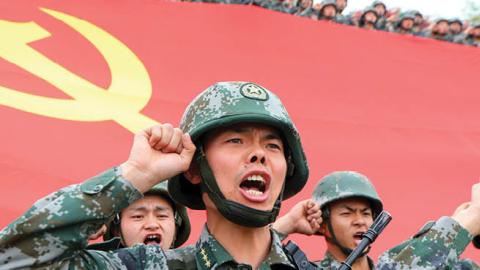 Members of the Communist Party of China (CPC) review the oath of joining the party in front of the party flag on April 13, 2021 in Luoyang, Henan Province of China. (Photo by Jia Fangwen/VCG via Getty Images)