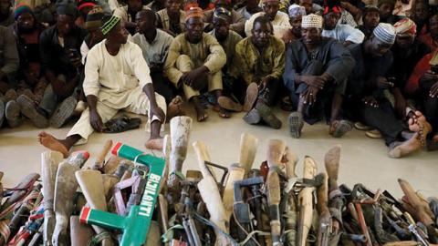 Members of the Yansakai vigilante group sit inside the Zamfara State Government house as their members surrendered more than 500 guns as part of efforts to accept the peace process of the state government (Photo by KOLA SULAIMON/AFP via Getty Images)