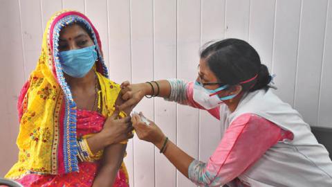 A resident of the street artists transit camp is inoculated against Covid-19 at Anand Parbat on May 10, 2021 in New Delhi, India. (Photo by Raj K Raj/Hindustan Times via Getty Images)