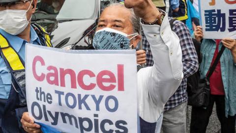 A protester holds a placard during a demonstration against the forthcoming Tokyo Olympic Games on June 06, 2021 in Tokyo, Japan (Photo by Yuichi Yamazaki/Getty Images)