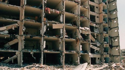 Debris lies on the ground by the wreckage of Khobar Towers in Dhahran, Saudi Arabia June 29, 1996 after a truck bomb exploded four days previously, killing 19 American servicemen residing there (Photo by Scott Peterson/Getty Images)