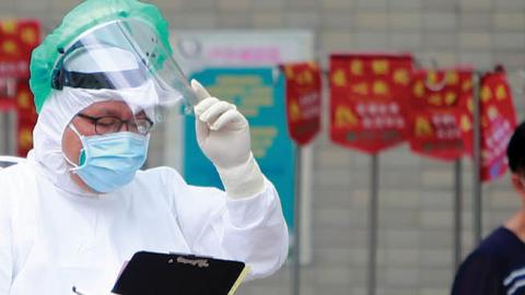 A medical worker wearing a PPE at Far Eastern Hospital triage patients who are receiving a Covid PCR test following a worsen local outbreak of COVID-19, in Taipei, Taiwan (Photo by Ceng Shou Yi/NurPhoto via Getty Images)