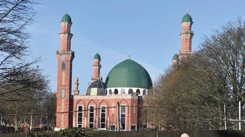 A lady walks past Al-Jamia Suffa-Tul-Islam Grand Mosque on February 12, 2021 in Bradford, England. (Photo by Nathan Stirk/Getty Images)