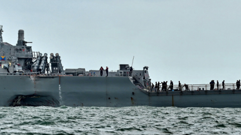 A general view shows the guided-missile destroyer USS John S. McCain with a hole on its left portside after a collision with oil tanker, outside Changi naval base in Singapore on August 21, 2017. (ROSLAN RAHMAN/AFP via Getty Images)