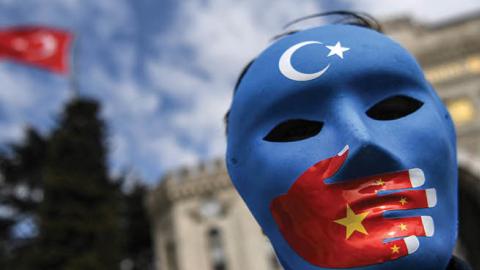A demonstrator wearing a mask painted with the colors of the flag of East Turkestan takes part in a protest by supporters of the Uighur minority on April 1, 2021 at beyazid square in Istanbul (Photo by OZAN KOSE/AFP via Getty Images)