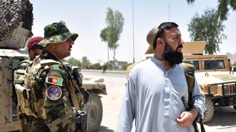 Afghan security personnel stand guard along the road amid ongoing fight between Afghan security forces and Taliban fighters in Kandahar on July 9, 2021 (Photo by JAVED TANVEER/AFP via Getty Images)