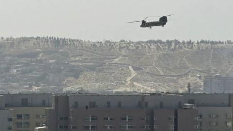 A U.S. Chinook military helicopter flies above the US embassy in Kabul on August 15, 2021. Several hundred employees of the US embassy in Kabul have been evacuated from Afghanistan, a US defense official said on August 15, 2021, as the Taliban entered the