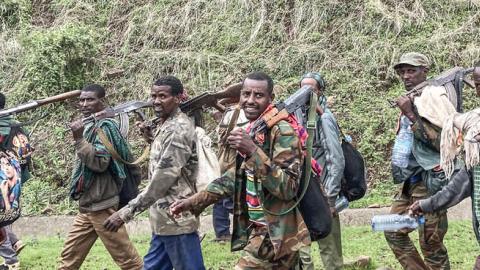 Members of the Amhara militia walk along the road in a rural area near the village of Adi Arkay, 180 kilometers northeast from the city of Gondar, Ethiopia, on July 14, 2021.