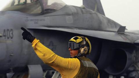 A plane director signals to the pilot of an F/A-18C Hornet from the "Wildcats" of Strike Fighter Squadron (VFA) 131 after landing on the flight deck of the Nimitz-class aircraft carrier USS Dwight D. Eisenhower (U.S. Navy)