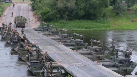 Battle Group Poland U.S., U.K and 15th Mechanized Brigade Polish tactical vehicles perform river crossing training June 19 in Rukla (U.S. Army photo by Spc. Kevin Wang/Released)