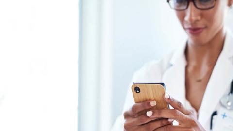 A medical professional uses her cell phone to access patient data. (Getty Images)