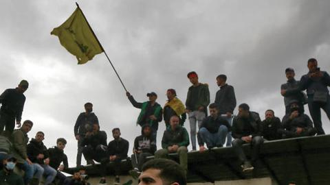 Pro-Iranian Hezbollah militants hold flags and shout slogans during the funeral procession of five men who were killed in clashes with Turkish army in the Syrian province of Idlib. (Marwan Naamani via Getty Images)