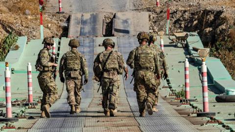 U.S. soldiers patrol an area near Syria's northeastern Semalka border crossing with Iraq's Kurdish autonomous territory, on November 1, 2021. (Photo by DELIL SOULEIMAN/AFP via Getty Images)