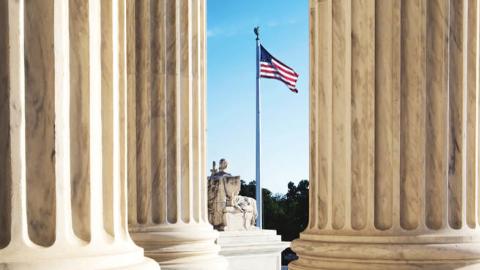 An American flag seen through columns at the United States Supreme Court. (Justin Tierney via Getty Images)