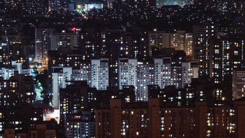 Aerial view of residential buildings at night. (AedalPerspective Image/Getty Images)