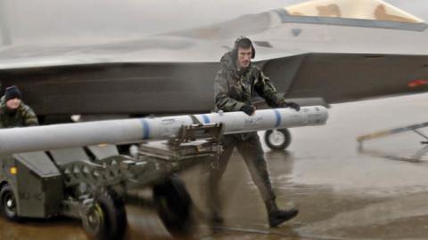 U.S. servicemen walk through rain and strong winds with an AIM-120 missile on January 31, 2006. (U.S Air Force photo by Staff Sgt. Eric T. Sheler)
