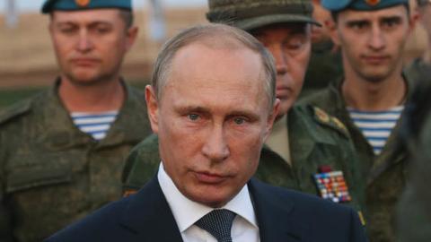 Russian President Vladimir Putin talks to officers as he attends Russias large-scale Center-2015 military exercises at Donguzsky Range September 19, 2015 in Orenburg, Russia. (Photo by Sasha Mordovets/Getty Images)