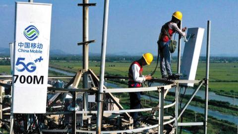 Workers of China Mobile set up 5G antennas on a tower on September 16, 2021 in Tongling, Anhui Province of China. (Photo by Guo Shining/VCG via Getty Images)