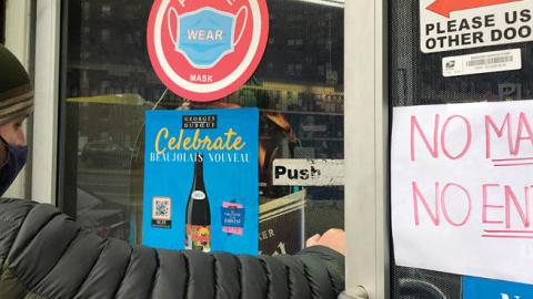 Man entering store with a "No Mask, No Entry" sign in Queens, New York. (Lindsey Nicholson/UCG/Universal Images Group via Getty Images)