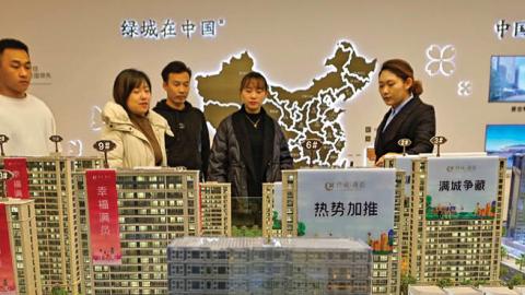 Home buyers look at models at a real estate sales office in Qingzhou city, East China's Shandong Province, Dec 21, 2021. (Wang Jilin/Costfoto/Future Publishing via Getty Images)