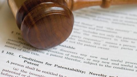 A gavel resting on the legal code outlining conditions for patentability. (csreed via Getty Images)