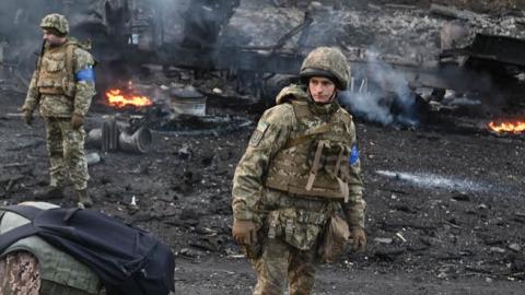 Ukrainian service members look for and collect unexploded shells after a fighting with Russian raiding group in the Ukrainian capital of Kyiv on February 26, 2022. (Photo by Sergei Supinsky/AFP via Getty Images)