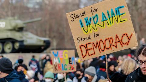 People gather in front of T-34 tank at a Soviet War Memorial to protest against the ongoing war in Ukraine on February 27, 2022 in Berlin, Germany. (Photo by Hannibal Hanschke/Getty Images)