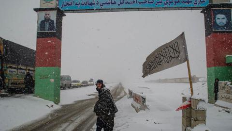 A man looks on at a snow-covered security checkpoint that marks the entrance to Logar province, beyond the southern gate on January 17, 2022 in Kabul, Afghanistan. (Photo by Scott Peterson/Getty Images)