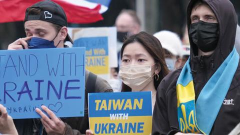 Protesters hold signs expressing their opinion during a protest against Russia's military invasion of Ukraine at the Liberty square in Taipei. (Photo by Walid Berrazeg/SOPA Images/LightRocket via Getty Images)