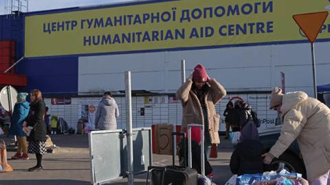 Families who have arrived from war-torn Ukraine stand outside a makeshift shelter and transit center on March 12, 2022 in Przemysl, Poland. (Photo by Sean Gallup/Getty Images)