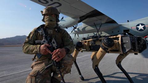 A member of the 321st Contingency Response Squadron security team stands next to a Ghost Robotics Vision 60 prototype during the Advanced Battle Management System exercise on Nellis Air Force Base, Nevada, Sept. 1, 2020. (US Air Force)