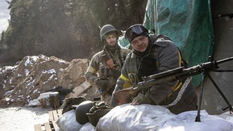 Members of the Ukrainian military wait at a forward position on the eastern frontline near Kalynivka village as Russian forces advanced on March 08, 2022, in Kyiv, Ukraine. (Photo by Chris McGrath/Getty Images)