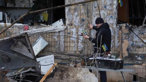 People remove rubble following the shelling of a residential area on March 14, 2022 in Kyiv, Ukraine. (Photo by Anastasia Vlasova/Getty Images)