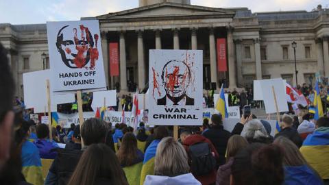 Protesters hold signs accusing Putin of war crimes as demonstrators gather in Trafalgar Square calling for unity against Russia on March 20, 2022 in London, England. (Photo by Martin Pope/Getty Images)