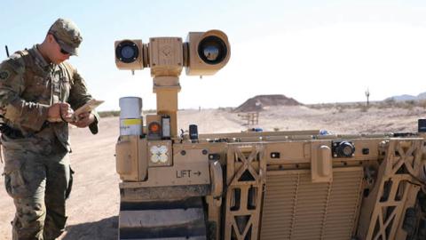 A soldier interacts with an unmanned ground vehicle during Project Convergence 2021. (U.S. Army/Marita Schwab)