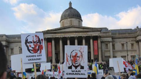 Protesters hold signs accusing Putin of war crimes as demonstrators gather in Trafalgar Square calling for unity against Russia on March 20, 2022 in London, England. (Photo by Martin Pope/Getty Images)