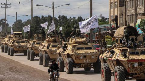 Taliban fighters in armoured vehicles take part in a military street parade in Herat on April 19, 2022.  (Photo by Mohsen Karimi/AFP via Getty Images)