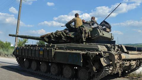 A tank sits outside Lysychansk, waiting to move into the city on June 19, 2022. (Photo by Madeleine Kelly/SOPA Images/LightRocket via Getty Images)