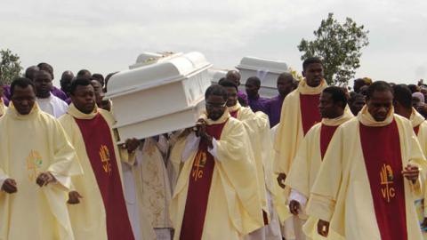 Clergymen carry white coffins containing the bodies of priests allegedly killed by Fulani herdsmen, for burial at Ayati-Ikpayongo in Gwer East district of Benue State, north-central Nigeria on May 22, 2018. (Emmy Ibu/AFP via Getty Images)