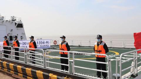 Officers of the China Coast Guard stand on deck as they set sail in the North Pacific Ocean from Shanghai, on July 30, 2021. (Photo by Xinhua via Getty Images)