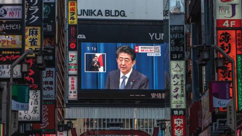Japan's Prime Minister Shinzo Abe appears on a giant television screen during a press conference announcing his resignation on August 28, 2020, in Tokyo, Japan. (Photo by Carl Court/Getty Images)