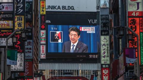 Japan's Prime Minister Shinzo Abe appears on a giant television screen during a press conference announcing his resignation on August 28, 2020, in Tokyo, Japan. (Photo by Carl Court/Getty Images)