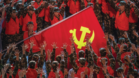 During a gala marking the 100th anniversary of the Communist Party, performers dressed as emergency workers surround a large Communist Party flag on June 28, 2021 at the Olympic Bird's Nest stadium in Beijing, China. (Photo by Kevin Frayer/Getty)