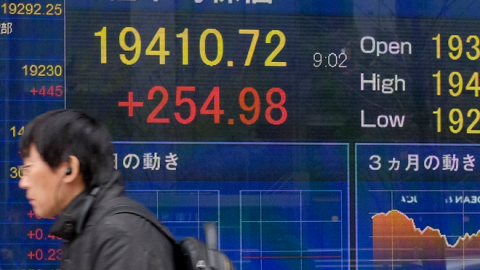 A pedestrian walks past a stock indicator board showing the share price of the Tokyo Stock Exchange in Tokyo on December 26, 2018. (KAZUHIRO NOGI/AFP/Getty Images)
