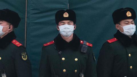 Chinese police wear protective masks as they stand guard on a main road on January 31, 2020 in Beijing, China (Photo by Kevin Frayer/Getty Images)