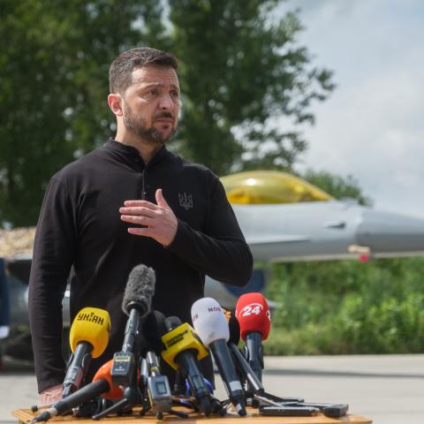 President of Ukraine Volodymyr Zelenskyi stands in front of the first General Dynamics F-16 Fighting Falcon received by Ukraine as he congratulates Ukrainian military on the Day of Ukrainian Air Force on August 4, 2024 in Unspecified, Ukraine. At the event for the Day of Ukrainian Air Force with the participation of President of Ukraine Volodymyr Zelenskyi, the first General Dynamics F-16 Fighting Falcons received by Ukraine were demonstrated. (Photo by Vitalii Nosach/Global Images Ukraine via Getty Images)