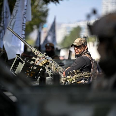 Taliban security personnel stand guard atop armored Humvees along a road in the Green Zone area in Kabul on August 12, 2026. (Getty Images)